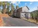 Three-story home on a lot with mature trees, attached garage and long paved driveway at 6904 Sprucedale Pkwy, Evergreen, CO 80439