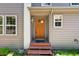 Inviting covered front porch with a half-glass wood door and steps at 6904 Sprucedale Pkwy, Evergreen, CO 80439
