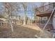 A spacious backyard features a wood fence, trees, and a deck attached to the home at 9551 E Chenango Ave, Greenwood Village, CO 80111
