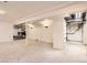 Finished basement area features carpet, white walls, support beams, and built in shelving at 9551 E Chenango Ave, Greenwood Village, CO 80111
