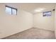 A finished basement provides extra living space with carpet, white walls and two small windows at 9551 E Chenango Ave, Greenwood Village, CO 80111