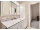 Bathroom with a marble countertop, vanity with storage, and mirrored medicine cabinet at 9551 E Chenango Ave, Greenwood Village, CO 80111