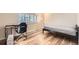 Bedroom featuring light wood floors, a desk, a bed, and window with plantation shutters at 9551 E Chenango Ave, Greenwood Village, CO 80111