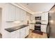 Beautiful kitchen featuring white cabinets, granite countertops, stainless steel appliances, and hardwood floors at 9551 E Chenango Ave, Greenwood Village, CO 80111