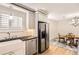 Bright kitchen features stainless steel appliances, white cabinets, stylish fixtures, and hardwood floors at 9551 E Chenango Ave, Greenwood Village, CO 80111