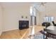 Bright living room boasts a statement fireplace, vaulted ceiling, large windows, and polished hardwood floors at 9551 E Chenango Ave, Greenwood Village, CO 80111