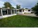A vibrant green backyard with a sunroom addition and white brick exterior create a serene outdoor space at 291 Magnolia St, Denver, CO 80220