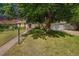 Charming home exterior with mature tree, green lawn, and an inviting walkway leading to the front door at 291 Magnolia St, Denver, CO 80220