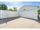 Garage exterior featuring a white door, siding, concrete driveway and fence with blue skies overhead at 291 Magnolia St, Denver, CO 80220