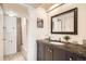 Well-lit bathroom with a bathtub, shower, granite countertop vanity, and a decorative mirror, combining style and functionality at 701 Harlan St # E59, Lakewood, CO 80214