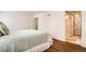 Bright bedroom featuring wood floors, a comfortable bed, and adjacent bathroom access, designed for rest and relaxation at 701 Harlan St # E59, Lakewood, CO 80214