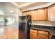 Modern kitchen equipped with black refrigerator, ample cabinet space, granite countertops, and a glimpse of the inviting living area at 701 Harlan St # E59, Lakewood, CO 80214