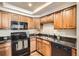 A well-lit kitchen features granite countertops and updated appliances, including a black oven and microwave at 701 Harlan St # E59, Lakewood, CO 80214