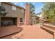 Spacious backyard featuring a large wooden deck, a brick chimney, and lush greenery at 7376 S Jackson St, Centennial, CO 80122