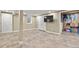 Finished basement area with tile floors, neutral paint, and an entertainment space with a television at 7376 S Jackson St, Centennial, CO 80122