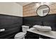 Charming half bathroom featuring black wainscoting, decorative wallpaper, and a vessel sink at 7376 S Jackson St, Centennial, CO 80122