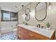 Modern bathroom featuring double sinks, a long vanity, large mirrors, and a walk-in shower at 7376 S Jackson St, Centennial, CO 80122