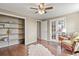 Bedroom featuring hardwood floors, ceiling fan, chair, shelving, and lots of natural light at 7376 S Jackson St, Centennial, CO 80122