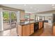 Open kitchen featuring a large island with seating, stainless steel appliances, and access to the outdoor patio at 7376 S Jackson St, Centennial, CO 80122