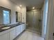 Modern bathroom featuring a double vanity with undermount sinks and a large glass-enclosed shower at 605 Twilight St, Erie, CO 80516