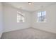 Bedroom with neutral carpet and natural light pouring in from the two large windows at 605 Twilight St, Erie, CO 80516