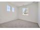 Bright bedroom featuring neutral carpet, white walls, and natural light from large windows at 605 Twilight St, Erie, CO 80516