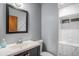 Modern bathroom with a sleek vanity, a well-lit mirror, and a stylish tiled walk-in shower at 7971 Olive St, Commerce City, CO 80022