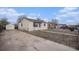 Side view of a single-story home with a detached garage and long concrete driveway, bathed in natural light at 7971 Olive St, Commerce City, CO 80022