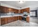 Traditional kitchen featuring wood cabinets, tile backsplash, and stainless steel appliances, with modern flooring at 7971 Olive St, Commerce City, CO 80022
