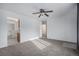 Spacious living room featuring neutral carpet, a ceiling fan, and an open layout connecting to the kitchen at 7971 Olive St, Commerce City, CO 80022