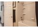 Tiled bathtub and shower combo, complete with built-in shelves, a rainfall shower head and soft lighting at 7409 S Alkire St # 304, Littleton, CO 80127