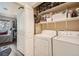 Convenient laundry area with washer, dryer, storage shelving, and access to a bedroom at 7409 S Alkire St # 304, Littleton, CO 80127