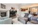 Open-concept living room flowing into kitchen with modern fireplace, large TV, and comfortable seating at 7409 S Alkire St # 304, Littleton, CO 80127