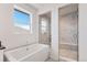 Bright and airy bathroom with a soaking tub, shower, and white marble tiles at 89 Clara Pl, Castle Pines, CO 80108