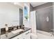 Modern bathroom featuring a granite vanity, white cabinets, and a gray-tiled shower and tub at 89 Clara Pl, Castle Pines, CO 80108