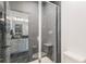 Modern bathroom with a sleek glass shower enclosure and luxurious black marble-style tile at 89 Clara Pl, Castle Pines, CO 80108