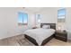 Bright bedroom featuring hardwood floors, two windows, and a patterned rug at 89 Clara Pl, Castle Pines, CO 80108