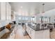 Bright, open kitchen with white cabinets, granite countertops, and a view of the dining area and neighborhood at 89 Clara Pl, Castle Pines, CO 80108