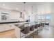 Open kitchen with island seating, modern lighting, and seamless flow into dining area at 89 Clara Pl, Castle Pines, CO 80108