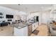 Spacious kitchen island featuring white cabinets, stone countertops, stainless steel appliances and barstool seating at 89 Clara Pl, Castle Pines, CO 80108