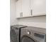 Efficient laundry room with modern, high-capacity washer and dryer units and overhead storage at 89 Clara Pl, Castle Pines, CO 80108