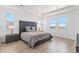 Bright main bedroom features an oversized bed, hardwood floors, and abundant natural light at 89 Clara Pl, Castle Pines, CO 80108