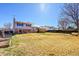 Open backyard featuring a large grass yard, mature trees and deck at 1244 S Argonne Cir, Aurora, CO 80017