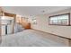 Partially finished basement with laundry area, carpet flooring, and natural light at 1244 S Argonne Cir, Aurora, CO 80017