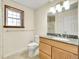 Bright bathroom with a wooden vanity and granite countertop and tile flooring at 1244 S Argonne Cir, Aurora, CO 80017