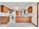 Functional kitchen with white appliances, wood cabinets, and a practical layout at 1244 S Argonne Cir, Aurora, CO 80017