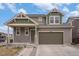 Charming two-story home featuring a two-car garage and a welcoming covered porch and beautifully landscaped front yard at 12921 E 108Th Way, Commerce City, CO 80022