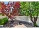 Shady backyard with mature landscaping, rocks, and a bird feeder at 150 Blue Spruce Ct, Highlands Ranch, CO 80126