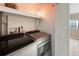 Convenient laundry room features modern Whirlpool washer and dryer with storage shelves at 150 Blue Spruce Ct, Highlands Ranch, CO 80126