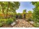 The backyard features a rock garden, flowering plants, mature landscaping, and a privacy fence at 10472 Longleaf Dr, Parker, CO 80134